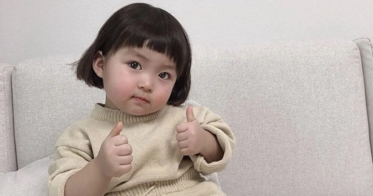 em bé cute giơ ngón tay cái