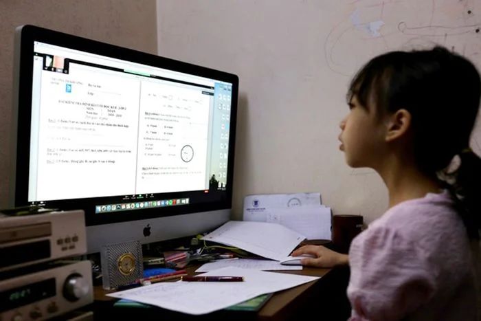 Bé gái đang tập trung học tập trên máy tính tại nhà