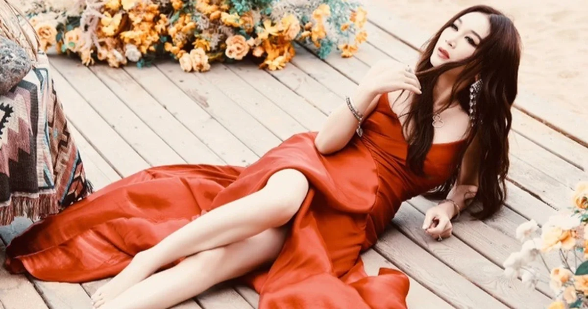 Ôn Bích Hà mặc váy đỏ quyến rũ nằm trên nền gỗ giữa vườn hoa