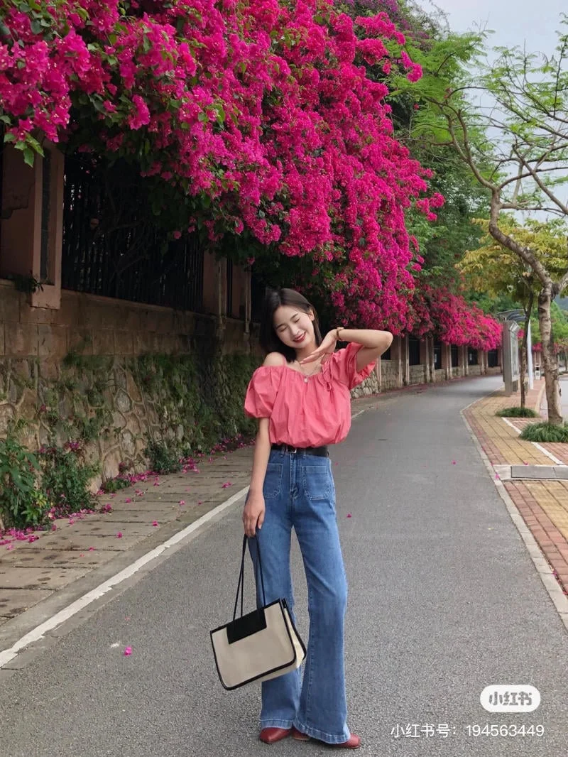 Cô gái trẻ tạo dáng chụp ảnh hoa giấy trên con đường thơ mộng